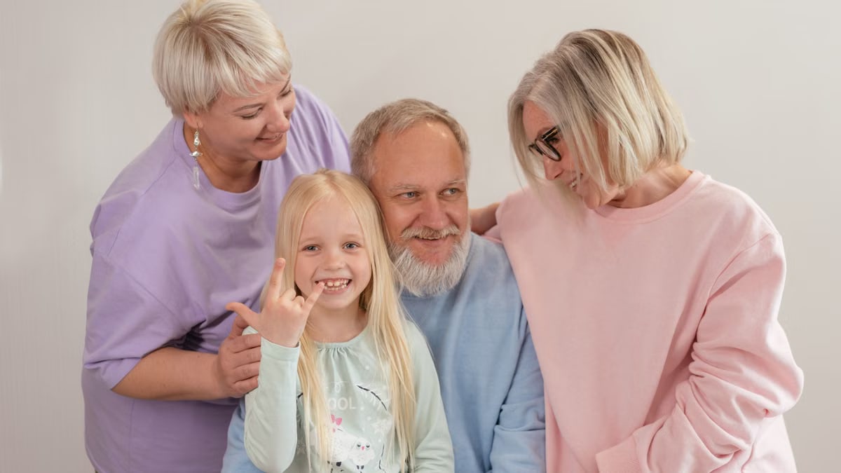 A joyful multigenerational family poses and smiles together indoors, showcasing love and togetherness.